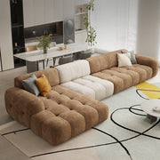 Brown sectional sofa in a modern living room with a dining area in the background.
